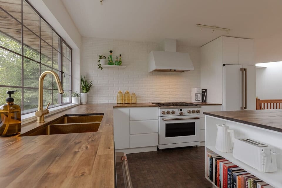 The large kitchen has full sized appliances with a propane cook stove and a beautiful view of the mountains.