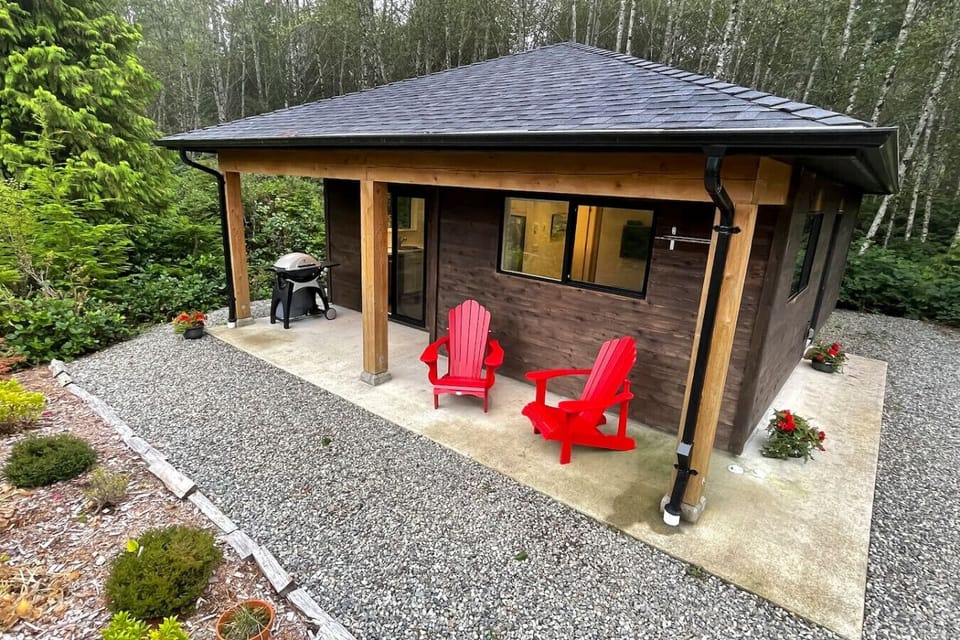 Outdoor sitting area and BBQ, front door, front door and parking area is located on the right hand side of the building from this view.