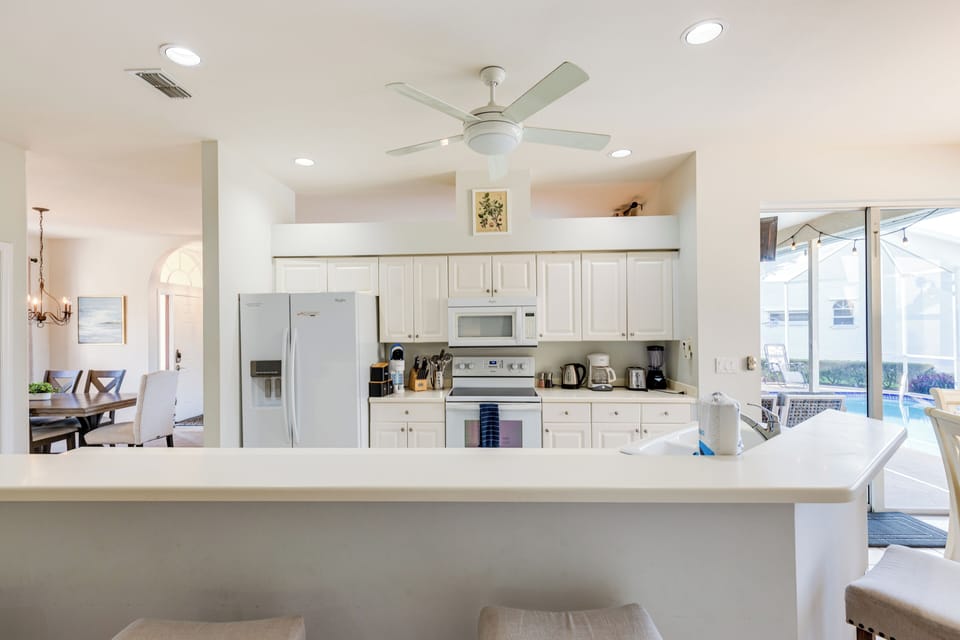 A fully equipped kitchen with modern appliances and bar seating.