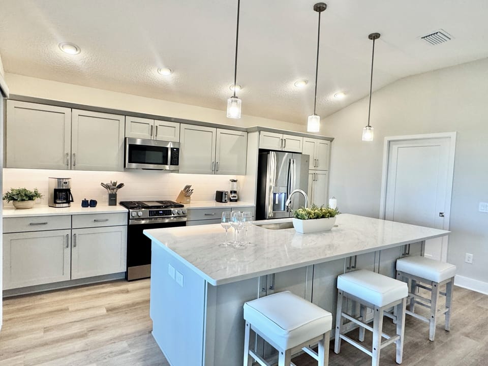 Kitchen Island and Stools and Utility Room to the Right