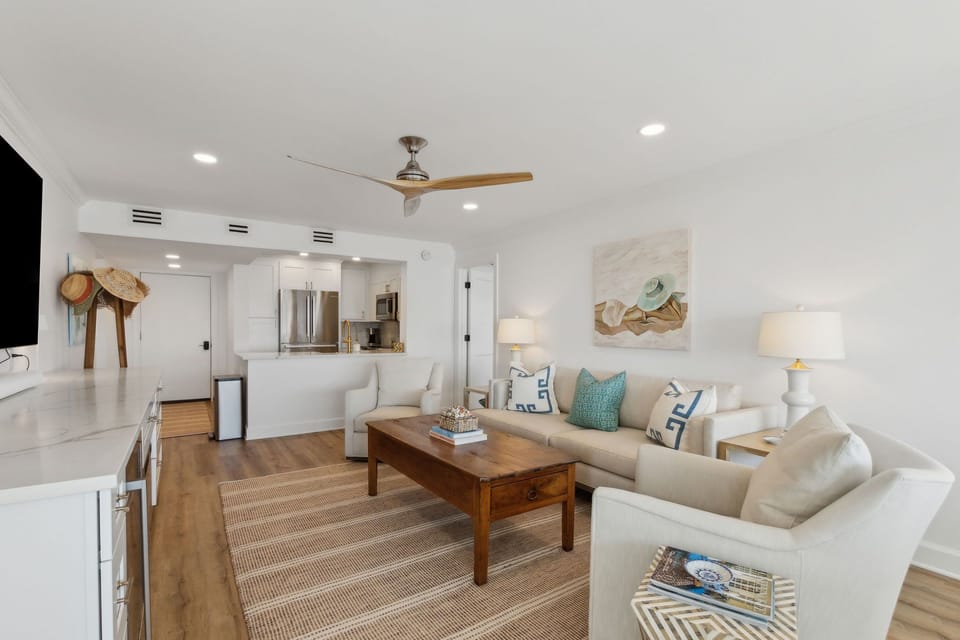 Luxury Living Area Featuring Plush Couch and Chairs, Flat Screen Smart TV, and Modern Coastal Decor
