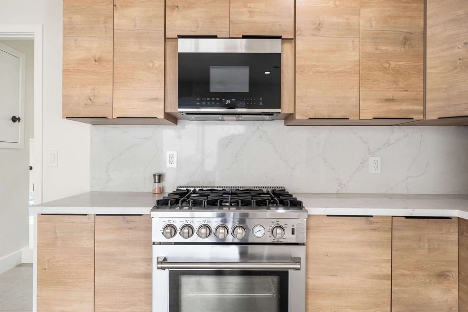 Perfect for culinary enthusiasts! Cook with ease on our stainless steel gas range, complemented by sleek cabinetry and a built-in microwave. The stylish backsplash and ample counter space make meal prep a joy.