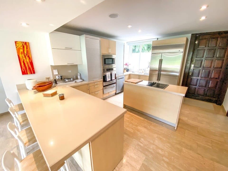 Kitchen:

Laminate–melamine countertops and cupboards
Four-upholstered bar-stool service countertop
Flat-top stove in center island
Conventional oven plus microwave oven
Double-door refrigerator
Dishwasher
