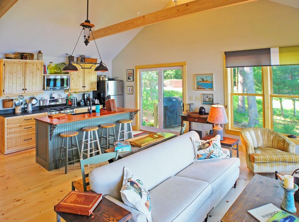 The living area is between the kitchen and great views of the Pond