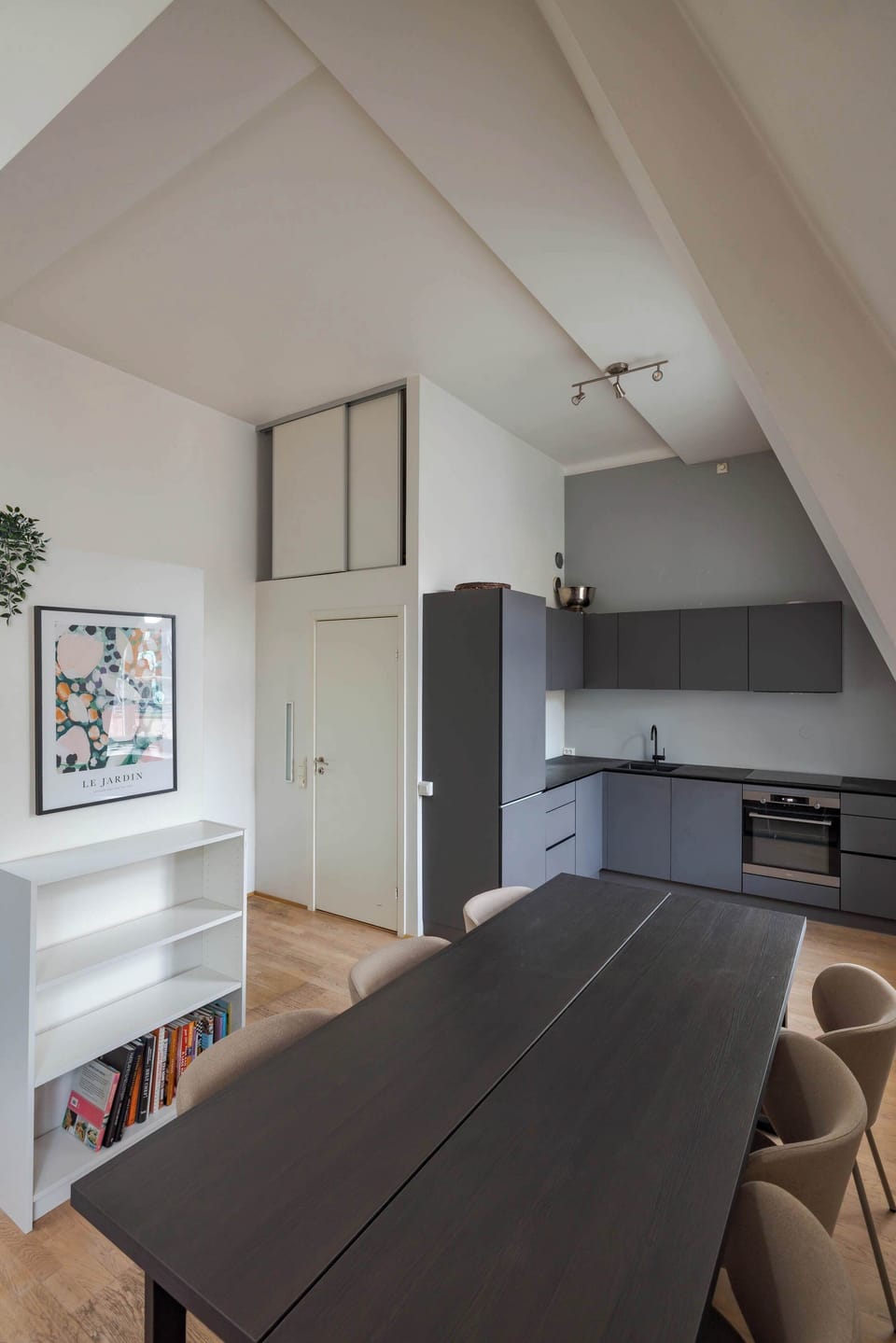 The dining area boasts a long, dark-wood table, ideal for gatherings.