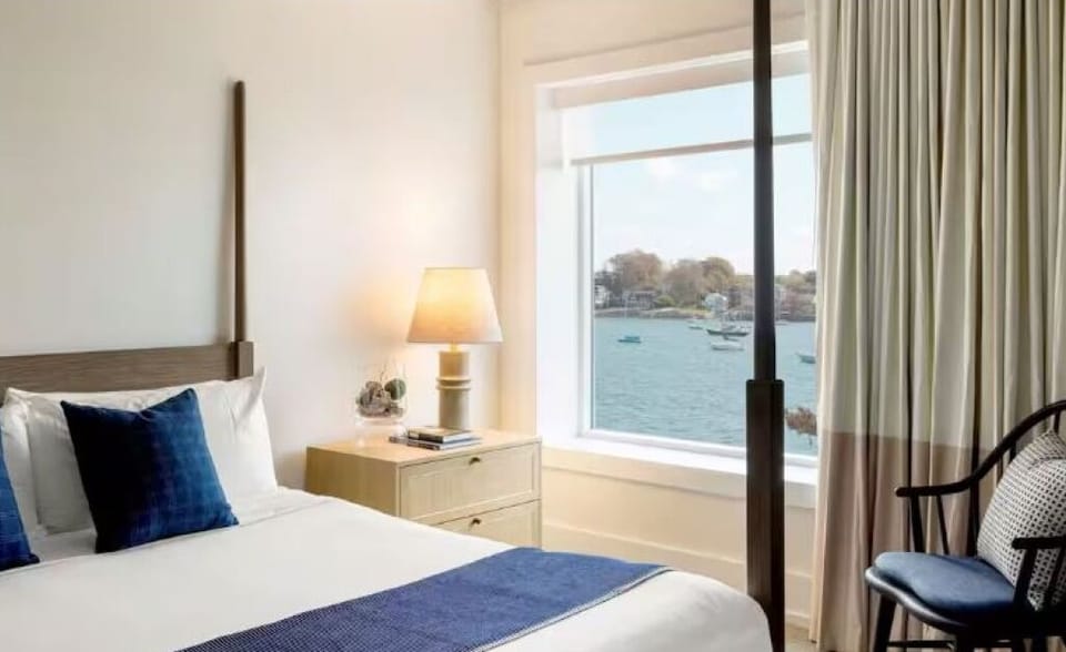 Wake to sunlit waterfront views beside a calm, cozy bed.