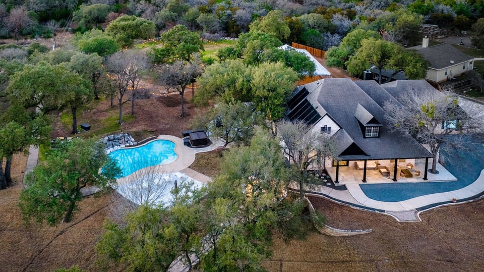 nestled among the trees, boasting a sparkling pool with a waterfall and a welcoming porch, offering a tranquil escape
