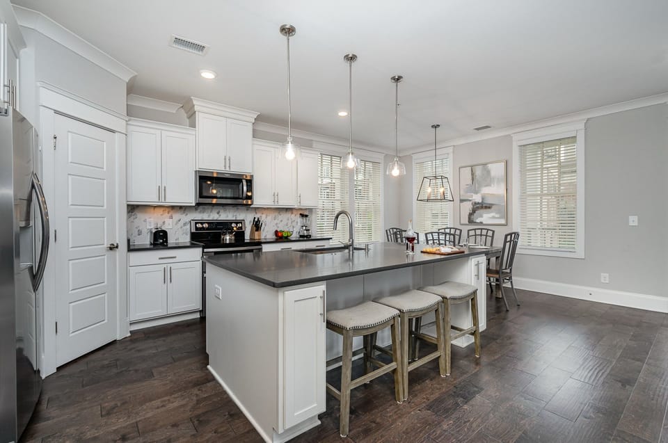 Fully equipped kitchen stocked with all culinary essentials, stainless steel appliances and an island offering bar seating for 3 guests.
