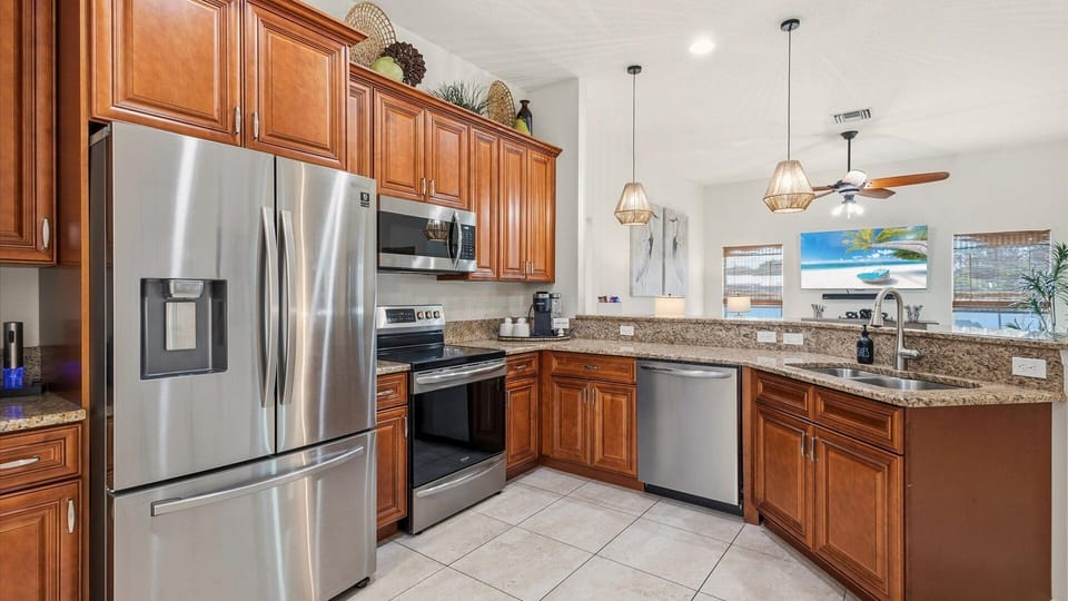 The kitchen features stainless steel appliances, granite countertops, and a breakfast bar that opens directly into the living room, completing the home's open layout.