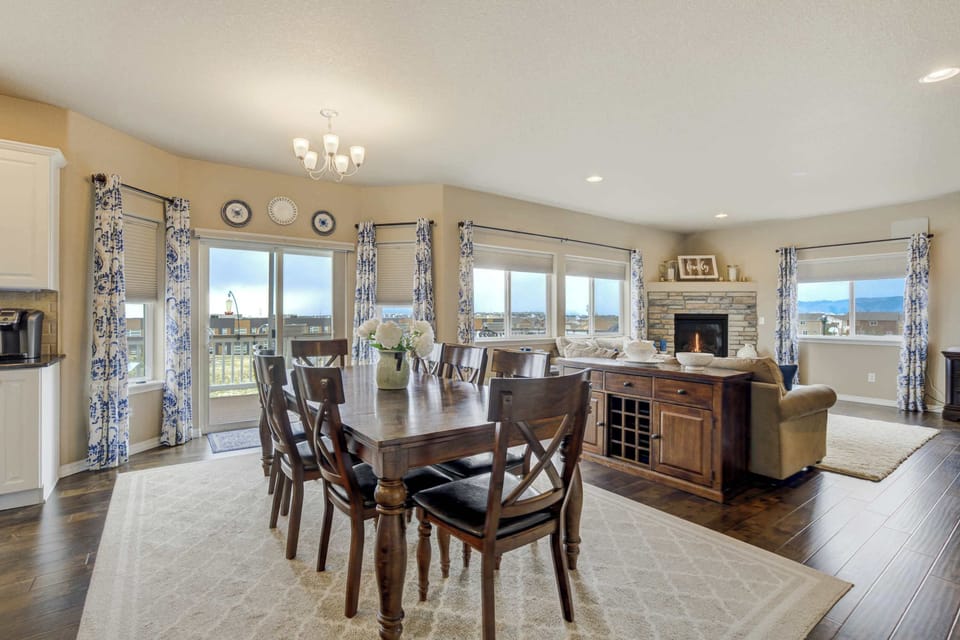 Elegant dining area with seating for the whole family, surrounded by large windows that showcase beautiful views. Perfect for enjoying meals together or hosting gatherings, with seamless access to the living room and kitchen.