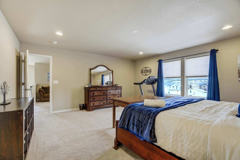 Expansive primary bedroom with a plush king-size bed, stylish furnishings, and large windows that fill the room with natural light. Includes a treadmill for staying active and a private ensuite bathroom for added convenience!







