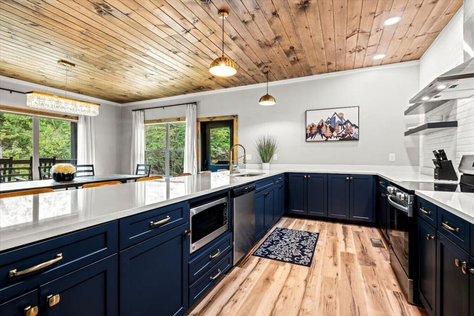 Cook up something special in this stunning kitchen, where navy cabinetry, white quartz, and brass details combine beauty with function.