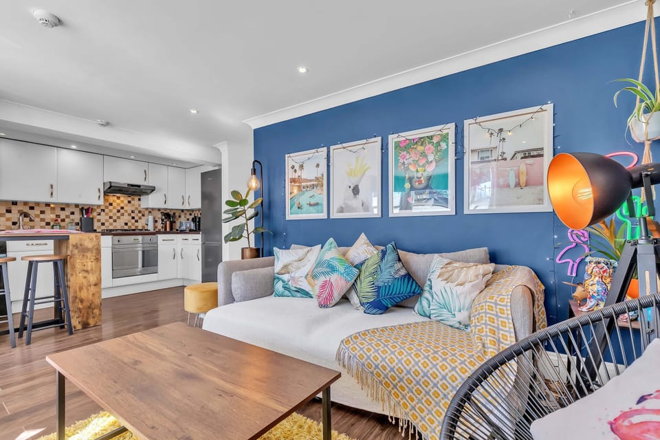 Open-plan kitchen with high-gloss cabinets, integrated appliances, and breakfast bar seating.