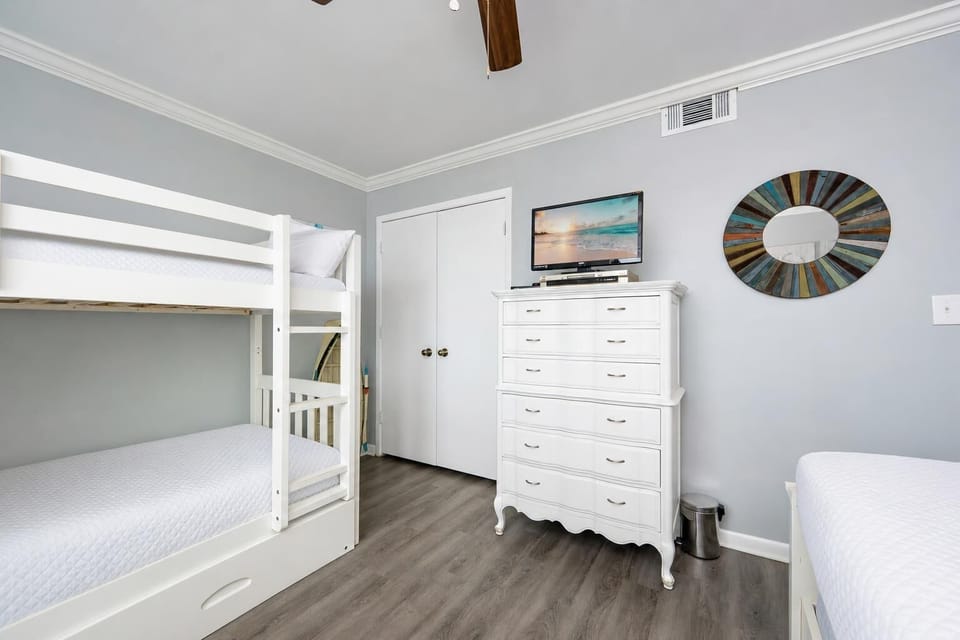 Twin over twin bunks in the guest room invite restful nights and TV time after a day along the shore