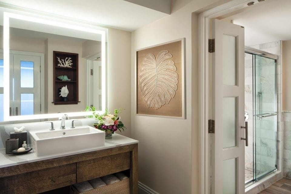 Refresh in a sleek bath with glowing mirror light.