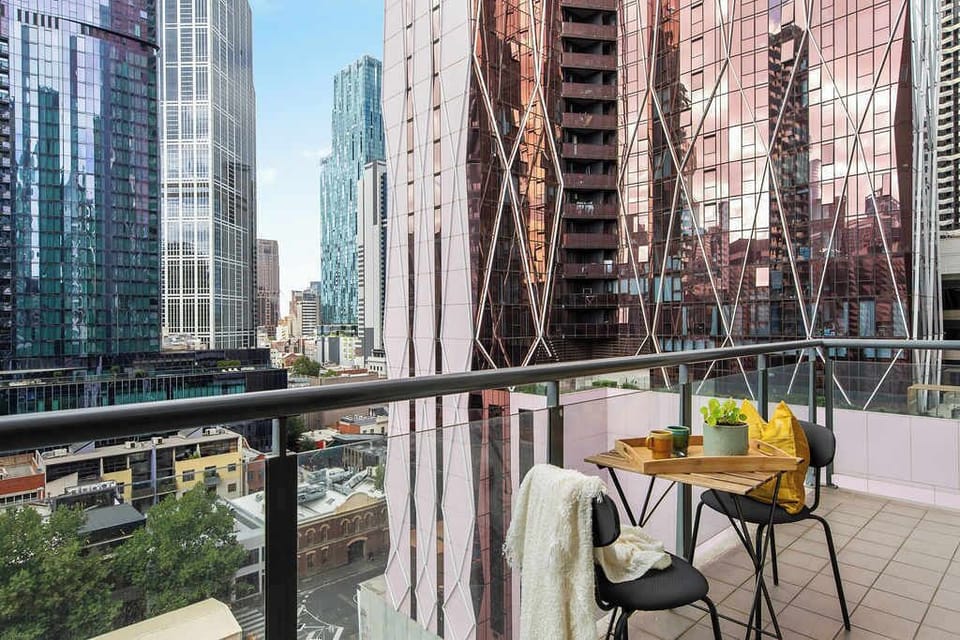 A balcony with a setting & city views.