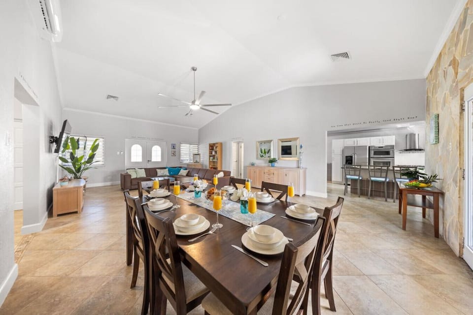 Spacious dining area with a large table, stylish decor, and kitchen.