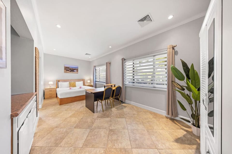 Bright living space with seating, dining table, and large windows.