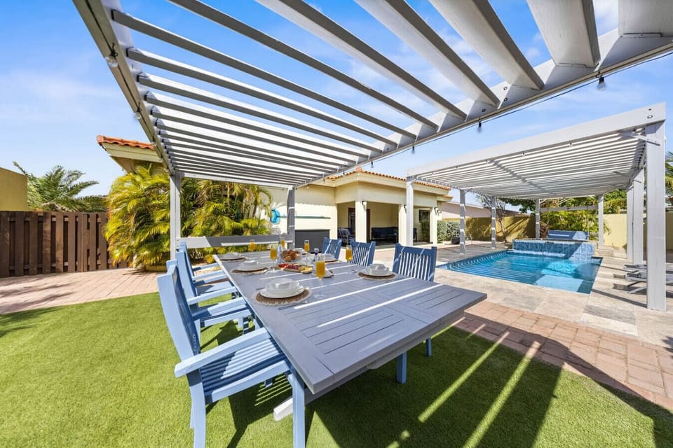 Covered outdoor dining area with pool view and seating for eight.