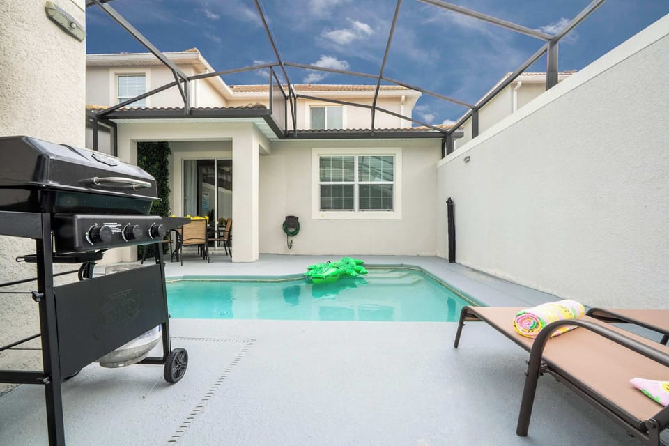 Splash into the screened-in pool and unwind under the covered lanai with dining for four - lush green wall and playful float bring instant vacation vibes.