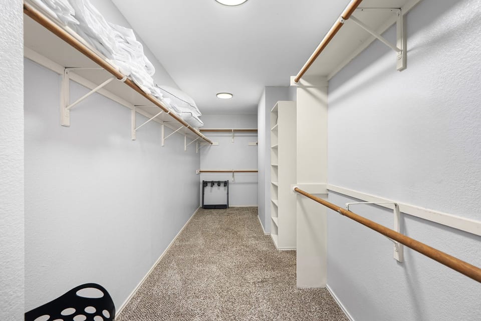 Walk-in master closet with ample storage and shelving