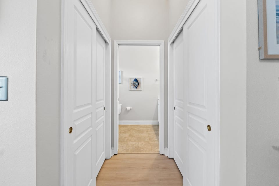 Step through this hallway of dual closets into your private ensuite bathroom—perfect for unwinding after a day at the beach.
