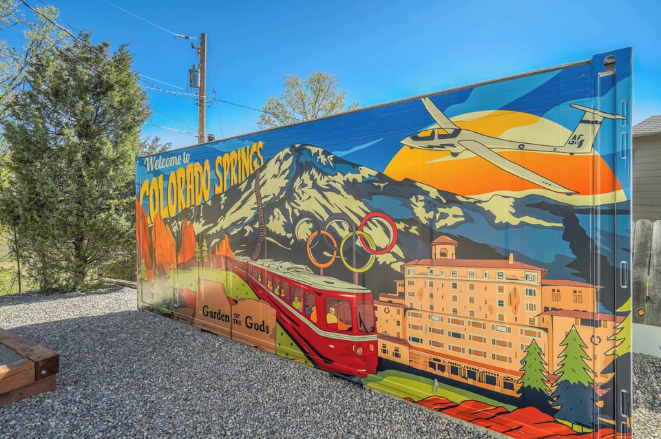 Vibrant Local Art! This colorful mural welcomes you to Colorado Springs, capturing iconic landmarks like Garden of the Gods and Pikes Peak. A perfect spot for photos and memories