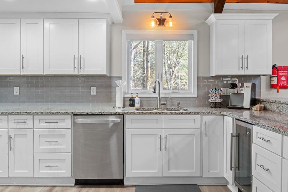 Clean and Ready to Cook
White cabinetry, stainless steel touches, and big windows keep this kitchen fresh, functional, and welcoming.