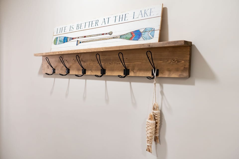 Welcome with a Smile
Charming wall hooks and a lake-inspired sign set the tone for a warm, relaxed stay the second you walk in.