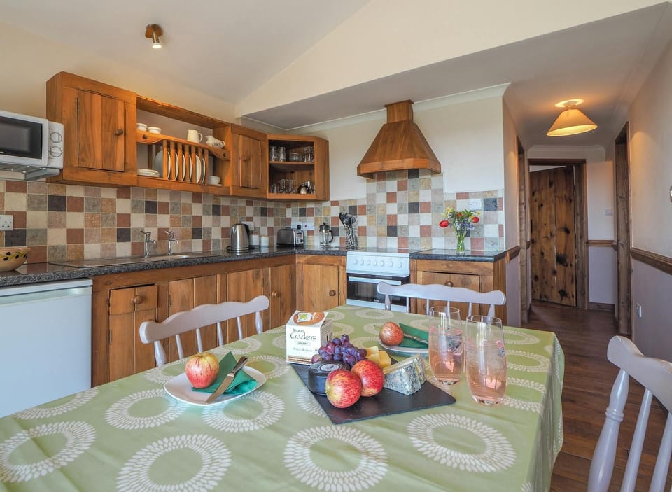 Kitchen and dining area, wooden kitchen units, cooker and cooker hood, dining table