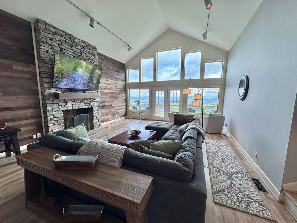 The Living Room has beautiful views, a huge sectional and two chairs, & 86" TV