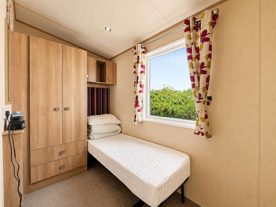 Practical single caravan bedroom, designed to offer comfort and functionality for your UK travels!