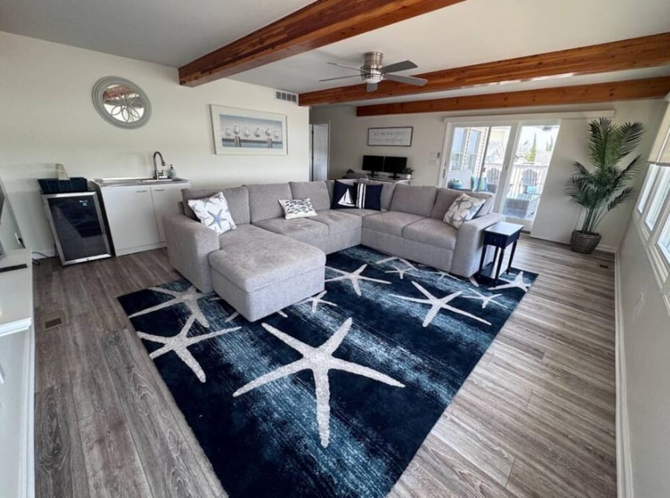 First floor living area with large sectional and beverage fridge with sink area