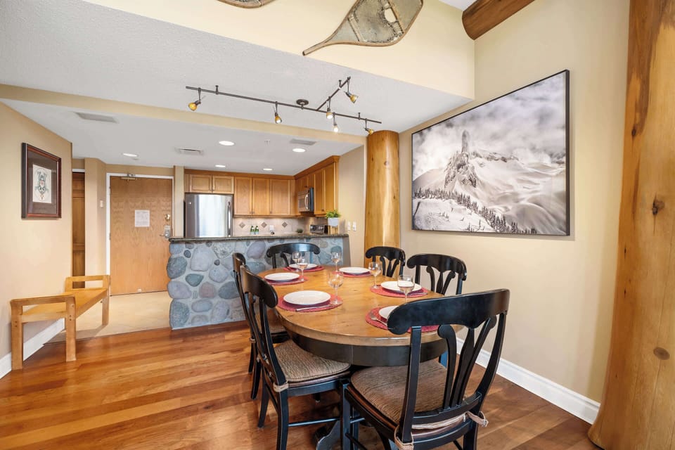 - Spacious dining area featuring log-style columns and rustic mountain artwork  
- Set the table for family dinners surrounded by warm wood and cozy lighting  
- Open layout flows seamlessly into the kitchen and living area for easy hosting