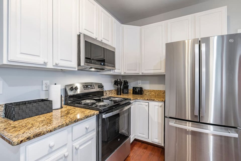 Where the magic happens! This fully stocked kitchen has all the essentials—floor-to-ceiling cabinet space, large granite countertops, a charming coffee nook, and bar seating so everyone can gather ‘round while the chef does their thing.