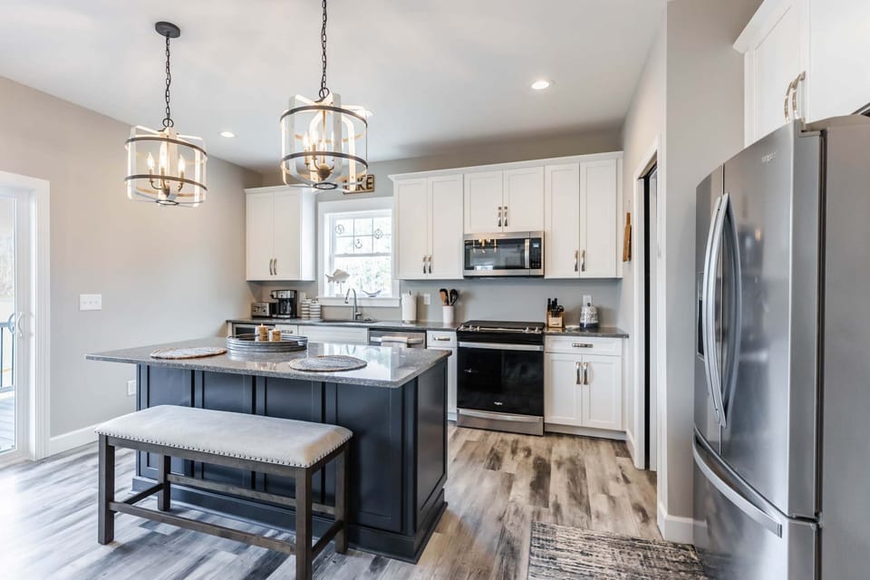Spacious kitchen island, bar seating, and stylish lighting—entertain, prep, or sip wine in style.