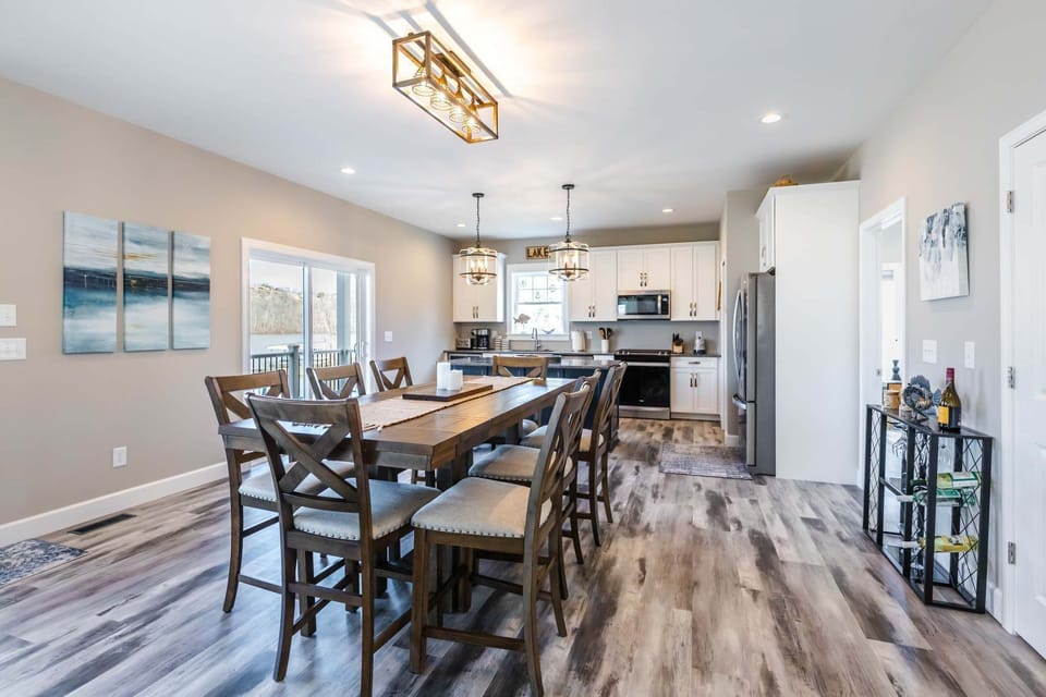 Large farmhouse-style dining table, designer lighting, and lake views—perfect for shared meals and laughter. 