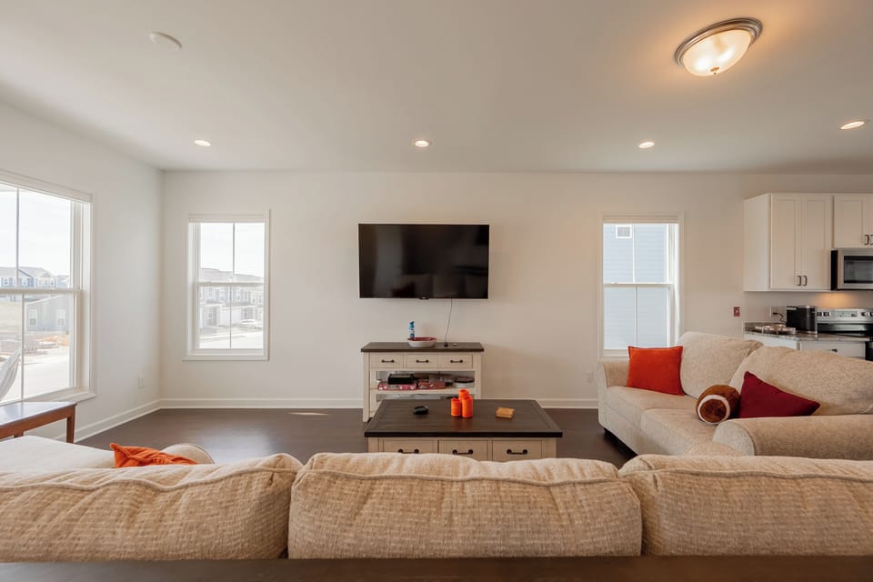 Cozy living room with smart TV, stylish decor, and room for the whole group.
