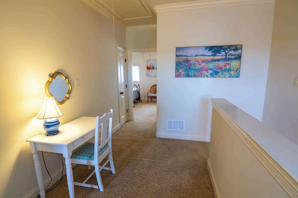 As you move to the upper level, a dedicated desk area awaits, perfect for work or catching up on personal projects in a quiet, comfortable space.