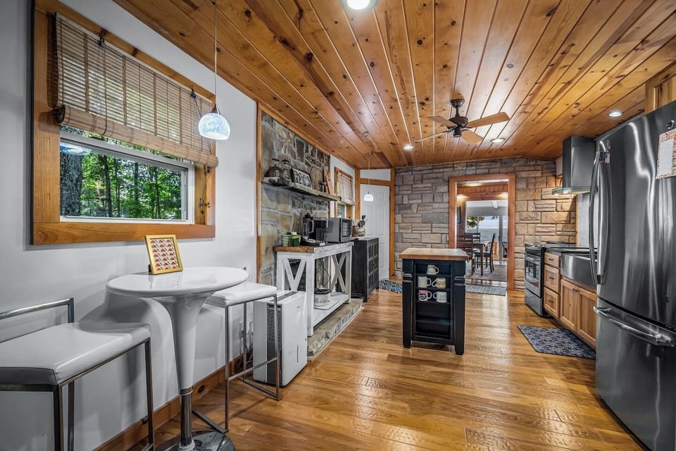With warm wood cabinetry, rock walls, and iconic design touches from the 1950s and `60s, this space blends nostalgic charm with modern convenience.