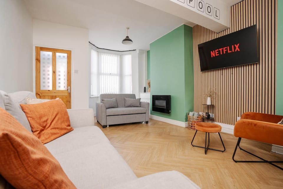 The comfortable living space includes a Smart TV with Netflix, a sofa bed for additional sleeping space, and a chair with an ottoman set—perfect for relaxing after a long day.