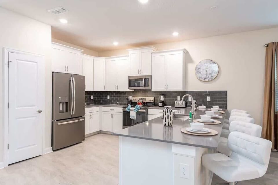 Stylish chef’s kitchen with sleek counters, modern appliances, and bar seating!