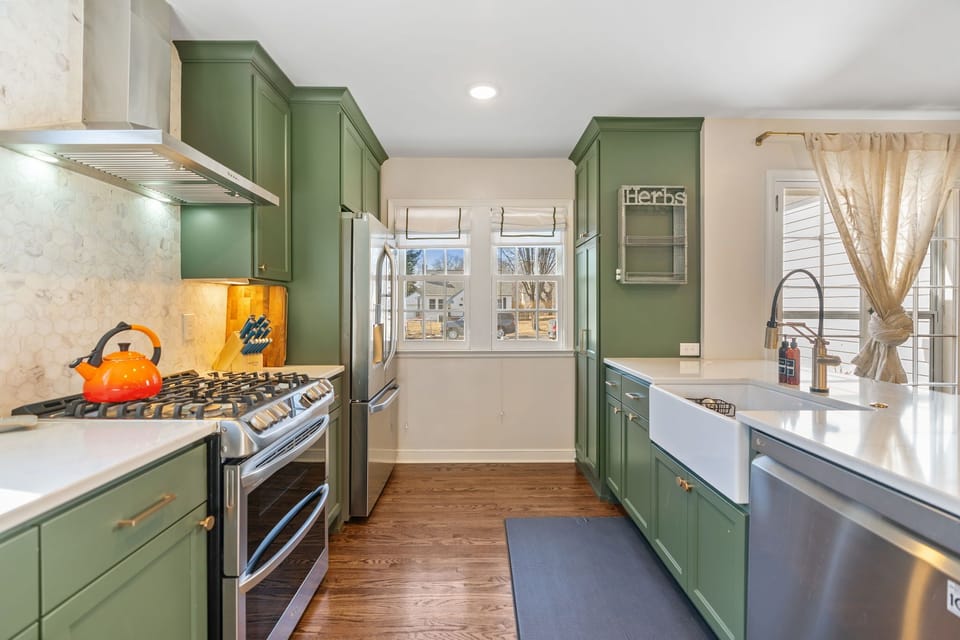 Your fully equipped kitchen invites culinary adventures with sage-green cabinets, stainless steel appliances, and everything needed to create memorable meals.
