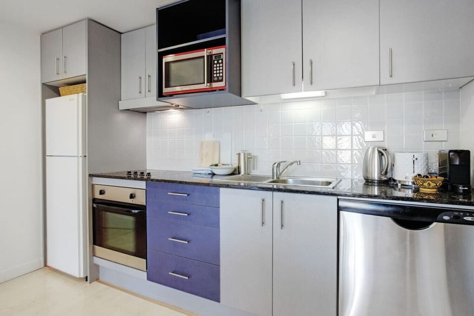 The kitchen has an oven, cooktop, microwave, dishwasher and fridge/freezer