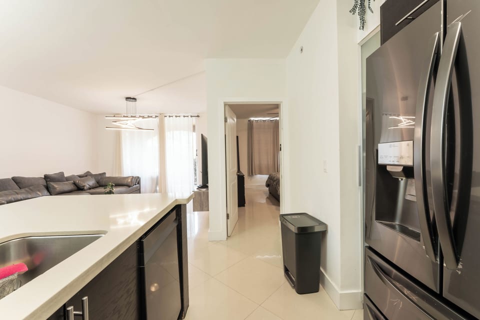 Open kitchen view with breakfast island, living room, and bedroom access