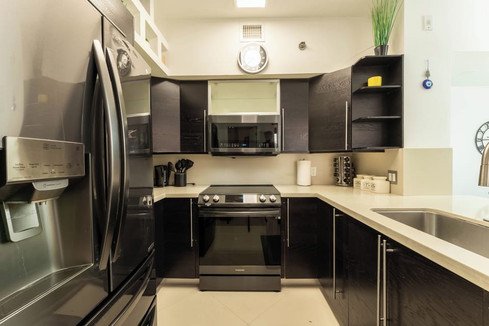Full kitchen with black cabinetry, gas range, and modern appliances