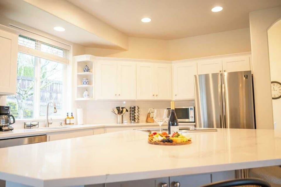 Whip up anything from quick bites to gourmet feasts in this modern kitchen with an expansive island, cozy nook, and all the cookware you need!