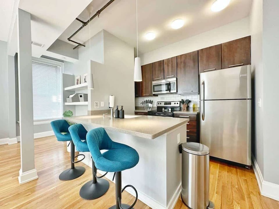 - Modern shared kitchen with stainless appliances and stylish bar seating  
- Bright open layout ideal for short term rental stays  
- Functional cooking space perfect for easy meal prep and quick snacks  
