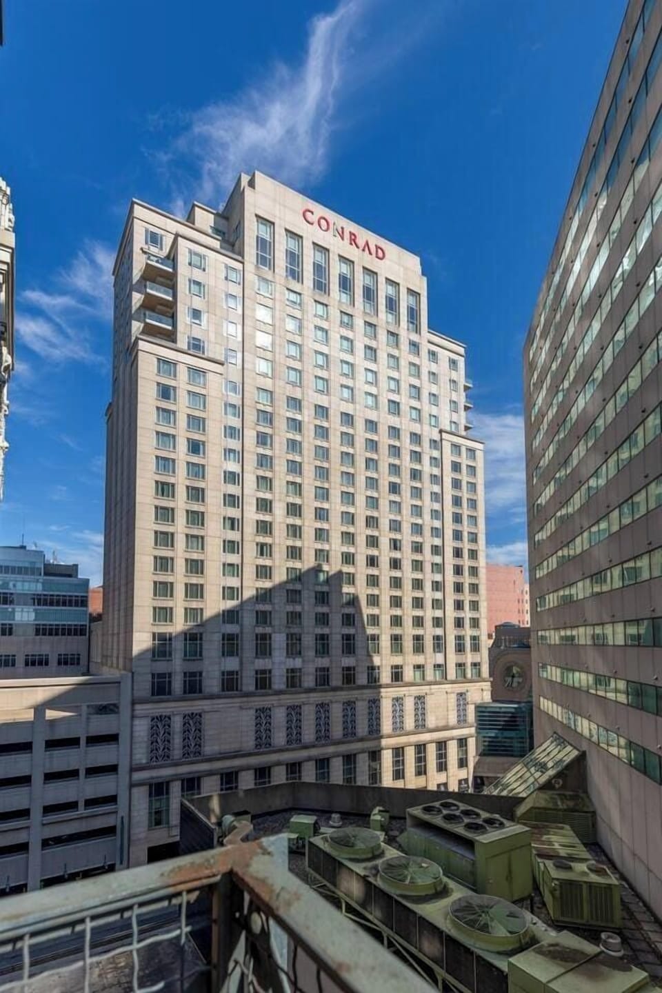 - High rise city view featuring the Conrad building and urban skyline 
- Bright blue sky and stunning architectural details all around 
- Prime downtown setting giving guests beautiful city perspectives 
