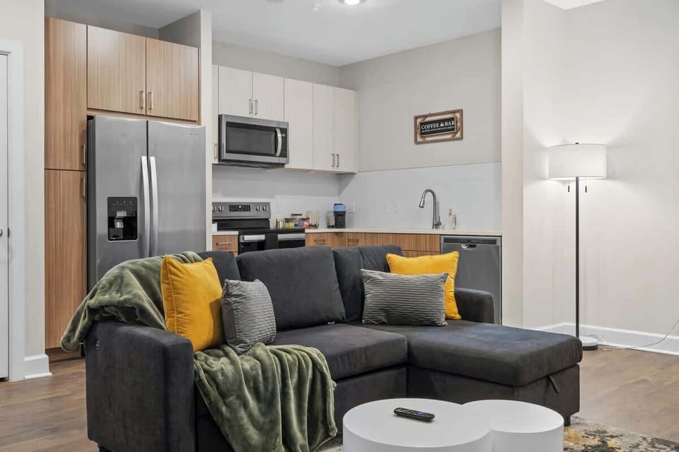 - Open-concept living area with stylish sofa and bright accents  
- Modern kitchen setup enhances your convenient Airbnb stay  
- Warm wood floors and lighting create an inviting atmosphere  
